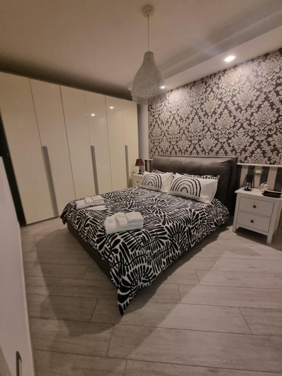 a bedroom with a bed with a black and white comforter at Home Santa Chiara Marigliano in Marigliano