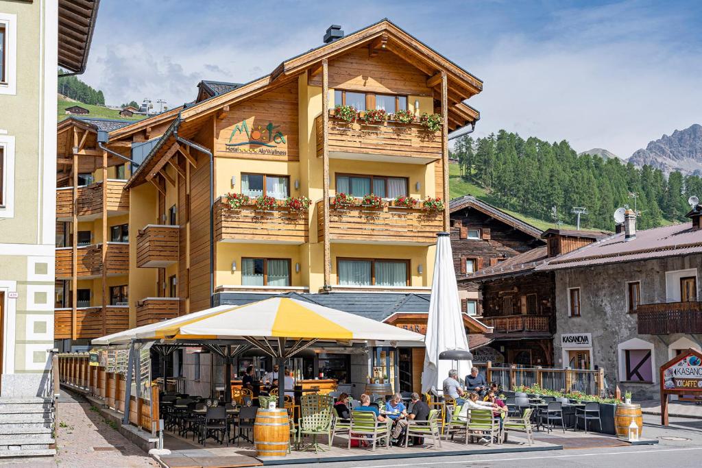 people sitting at tables in front of a hotel at MOTA hotel in Livigno