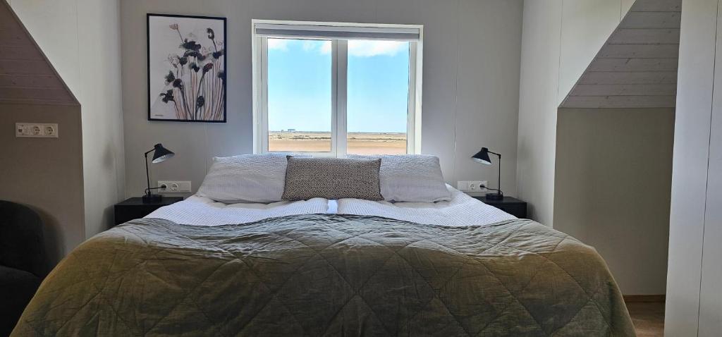 a bedroom with a bed with a view of the beach at Kviholmi Premium Apartments in Hvolsvöllur
