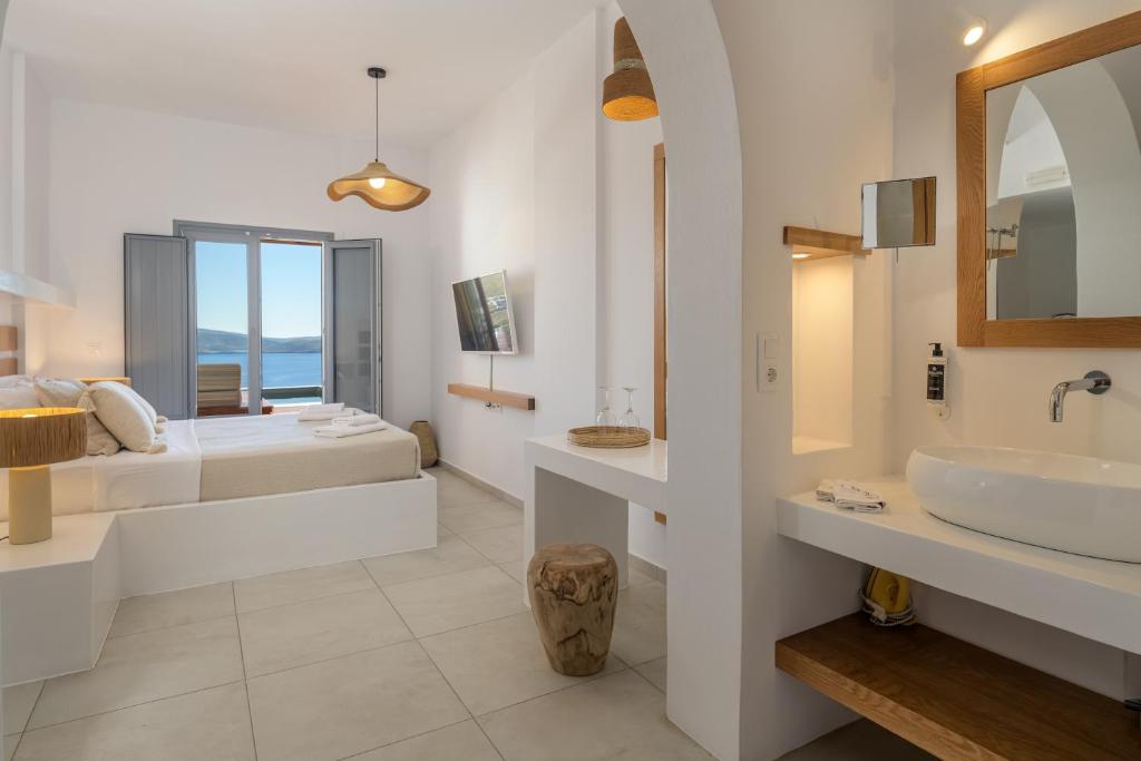 baño con 2 camas, lavabo y espejo en Oneiro Luxury Suites-Adults Only en Astipalea