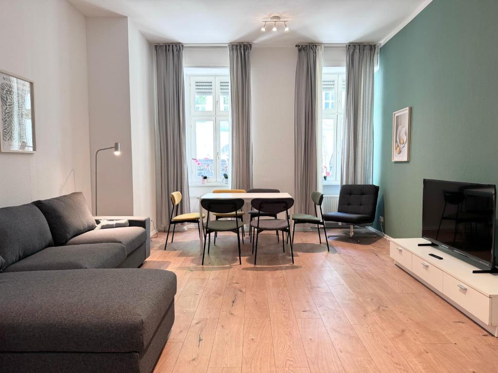 salon z kanapą, stołem i krzesłami w obiekcie Be in Berlin Apartments at Charlottenburg Castle w Berlinie