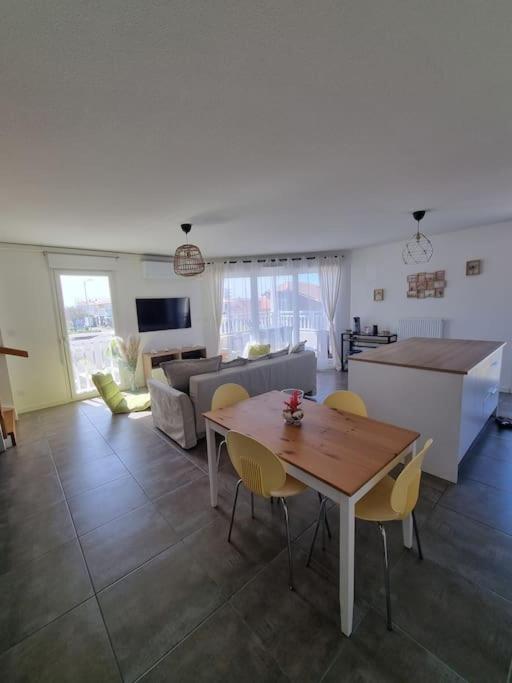 une cuisine et un salon avec une table et des chaises dans l'établissement Appartement Villa Trencat, à Biscarrosse