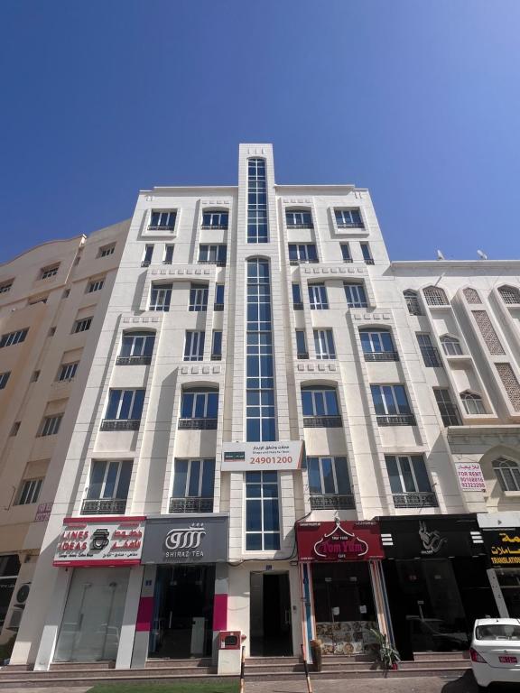 een groot wit gebouw in een stadsstraat bij Blue Umbrella in Muscat