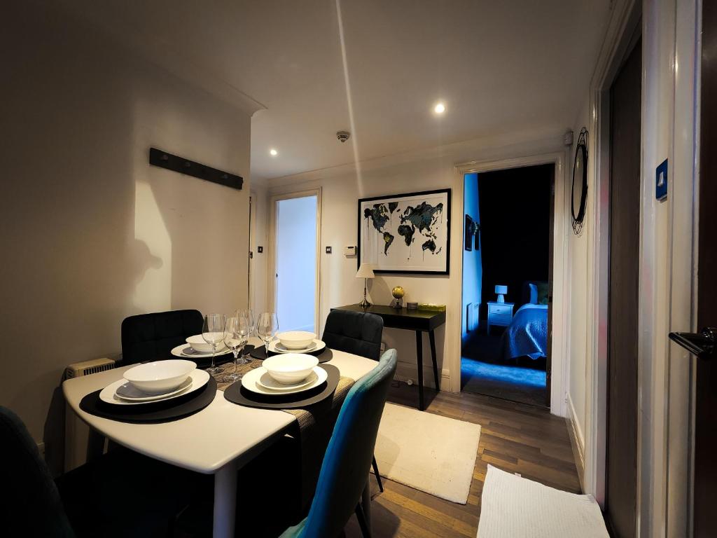 a dining room with a table and chairs and a living room at Apartment Near British Parliament in London