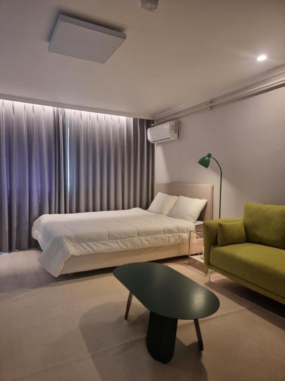 a bedroom with a bed and a green couch at Special House in Seoul