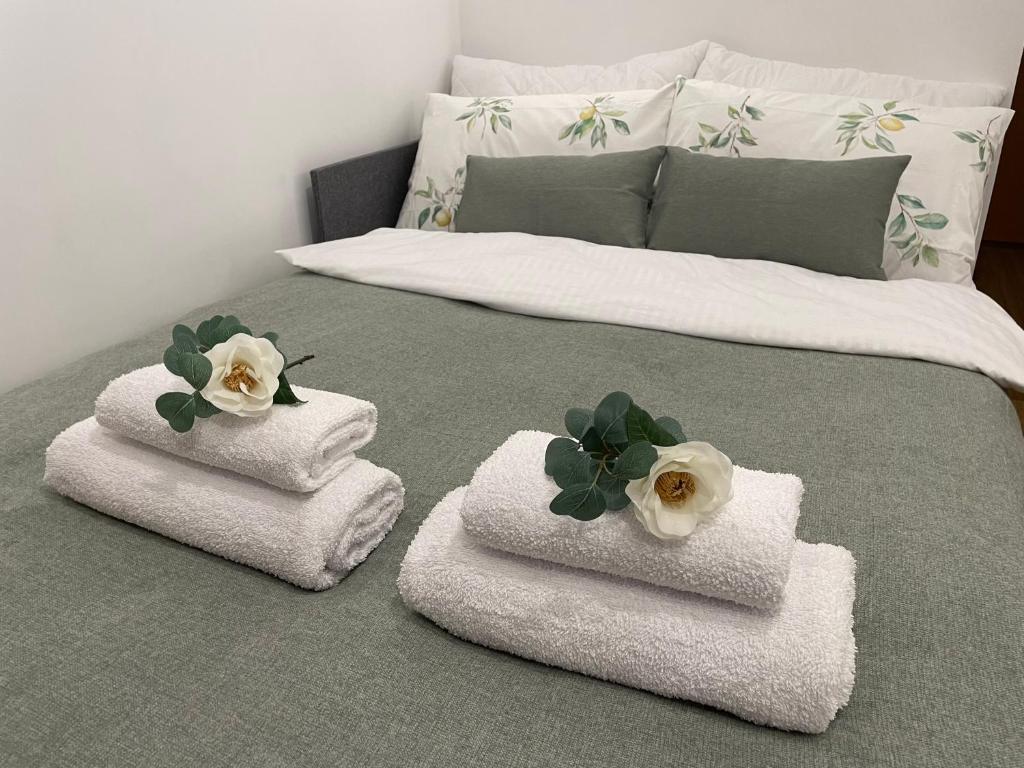 a bed with folded towels with flowers on it at Gdynia Riviera Hills in Gdynia