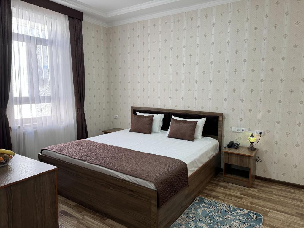 a bedroom with a bed and a window at Al-Khabib in Bukhara