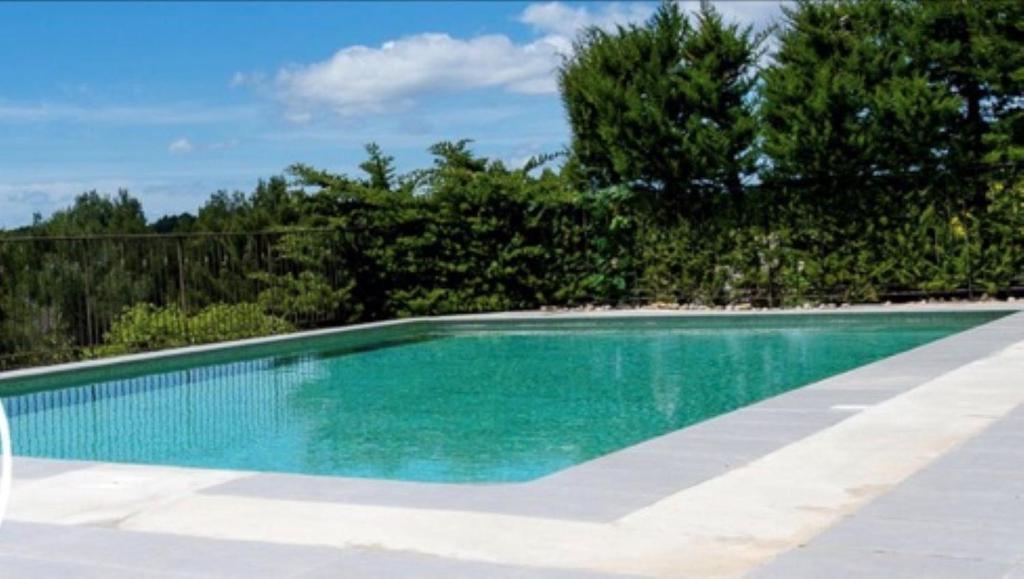 une piscine avec de l'eau bleue dans une cour dans l'établissement Villa d'architecte Parfaite pour les vacances !, à Montpellier