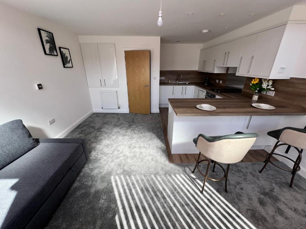 a living room with a couch and a kitchen at Flat 1 - Luxury Bolton City Centre Apartments in Bolton