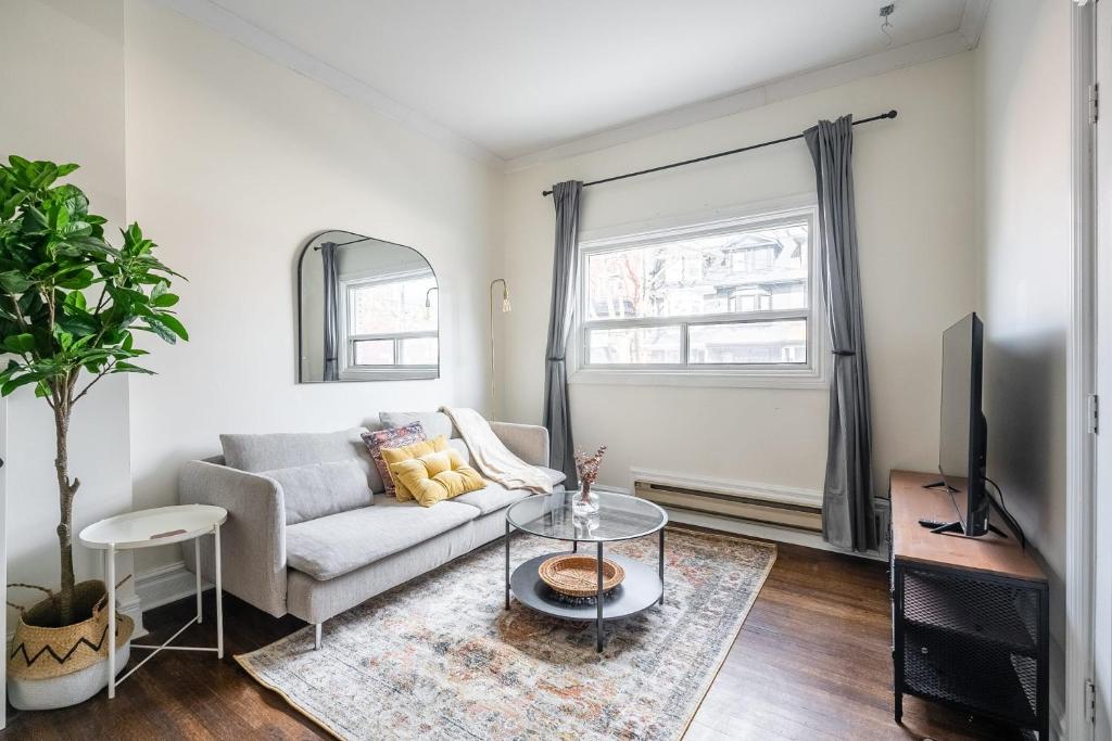 a living room with a couch and a tv at Modern Condo 1BR - Near Trinity Bellwoods Park in Toronto