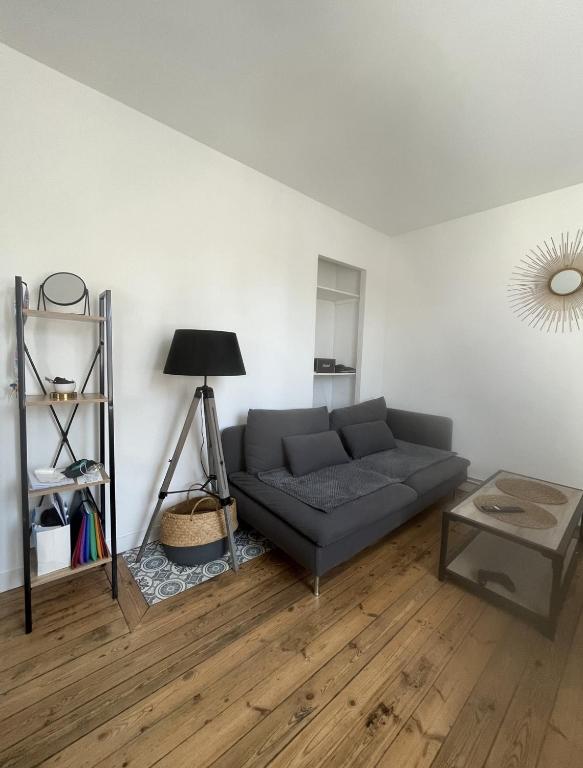 een woonkamer met een bank en een tafel bij Centre Bayeux in Bayeux