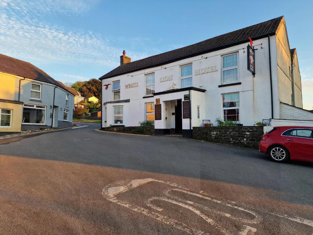 a red car parked in front of a building at Stunning 2-Bed House in Ferryside in Ferryside