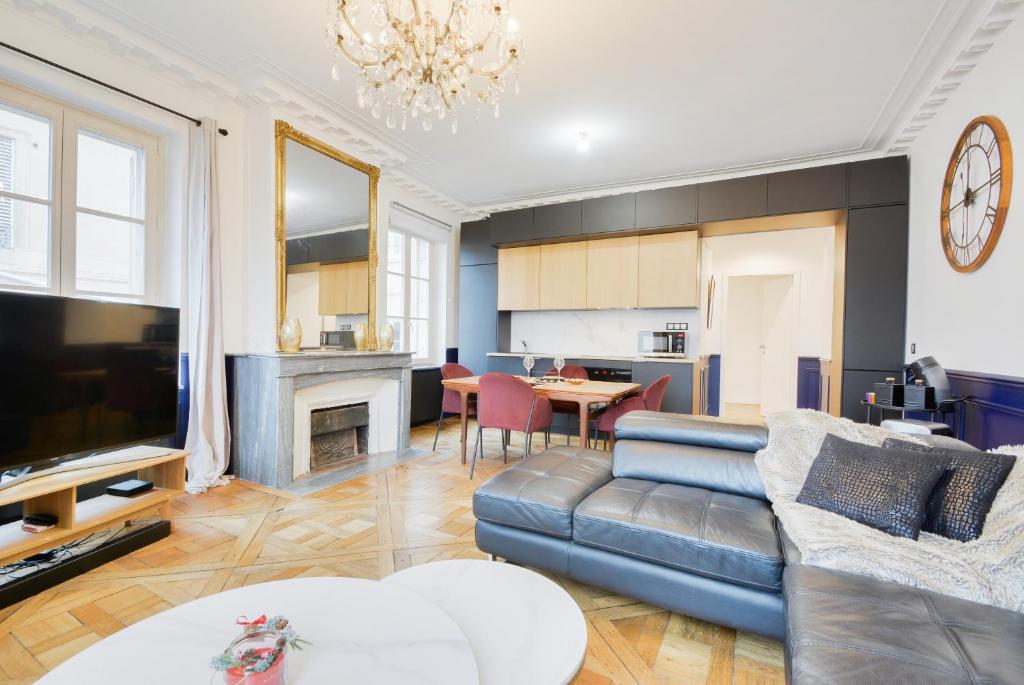 un salon avec un canapé et une télévision dans l'établissement Le Versailles de Nancy, à Nancy