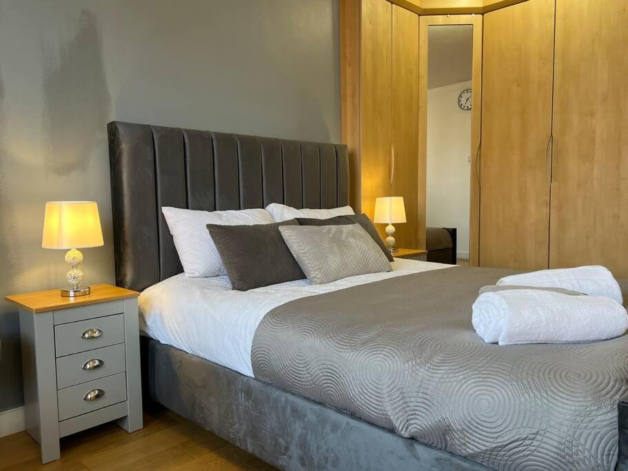 een slaapkamer met een groot bed met 2 kussens bij Duplex Apartment in Greater Manchester in Oldham