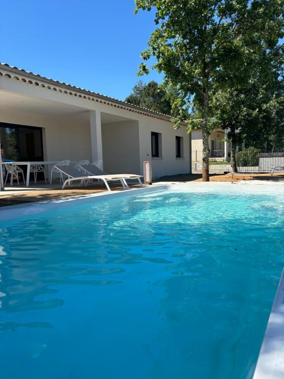 una grande piscina blu davanti a una casa di Villa du grangeon a Rosières