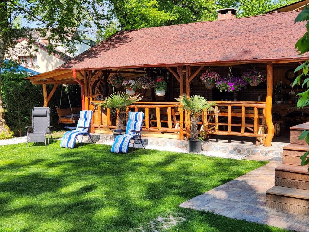 a wooden gazebo with blue chairs in a yard at Refugiul Rustic in Arad