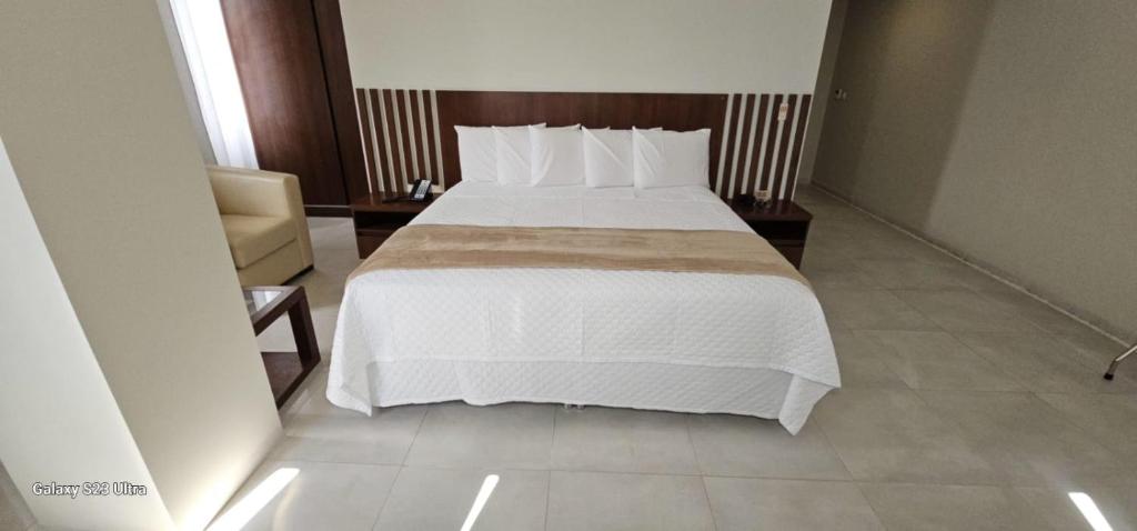a bedroom with a large bed with white sheets and pillows at Hotel Maywa in Santa Cruz de la Sierra