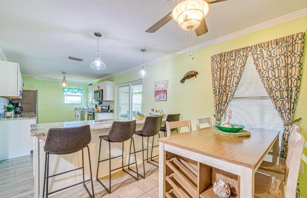 a kitchen with a wooden table and bar stools at Waterfront Hernando Beach Home with Dock and Hot Tub! in Hernando Beach