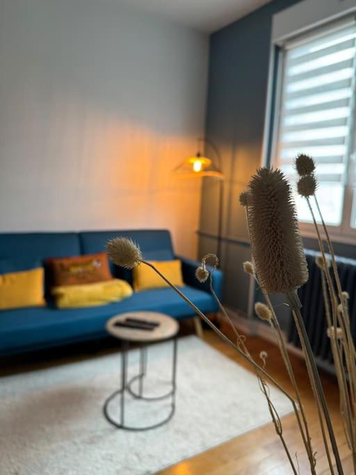 un salon avec un canapé bleu et une table dans l'établissement Constantine Suits 21 - Appartement 4 personnes Dijon centre, à Dijon