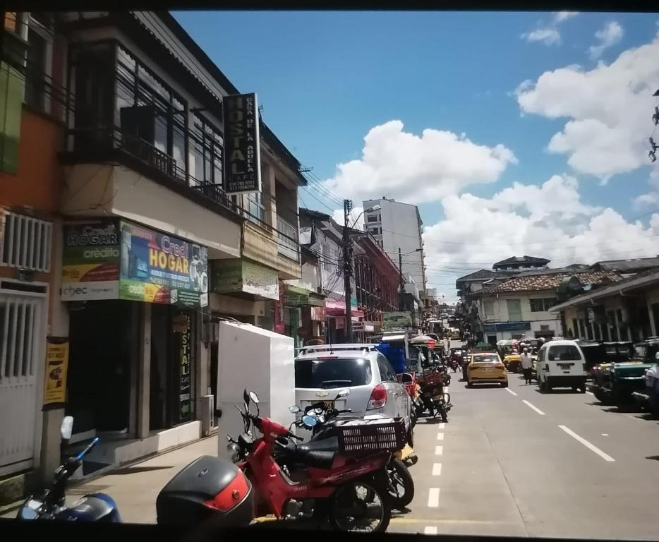 una calle de la ciudad con coches y motocicletas aparcados en la calle en Hostal cafe casa de la abuela, en Santa Rosa de Cabal