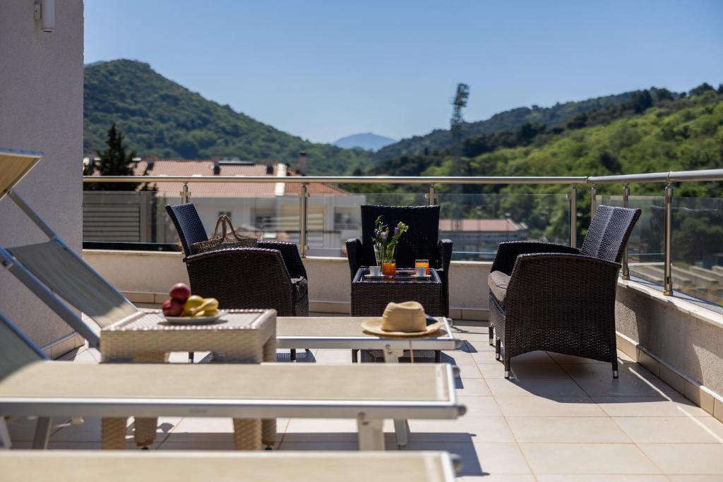 a balcony with chairs and tables on a roof at Apartments Del Mar in Petrovac na Moru