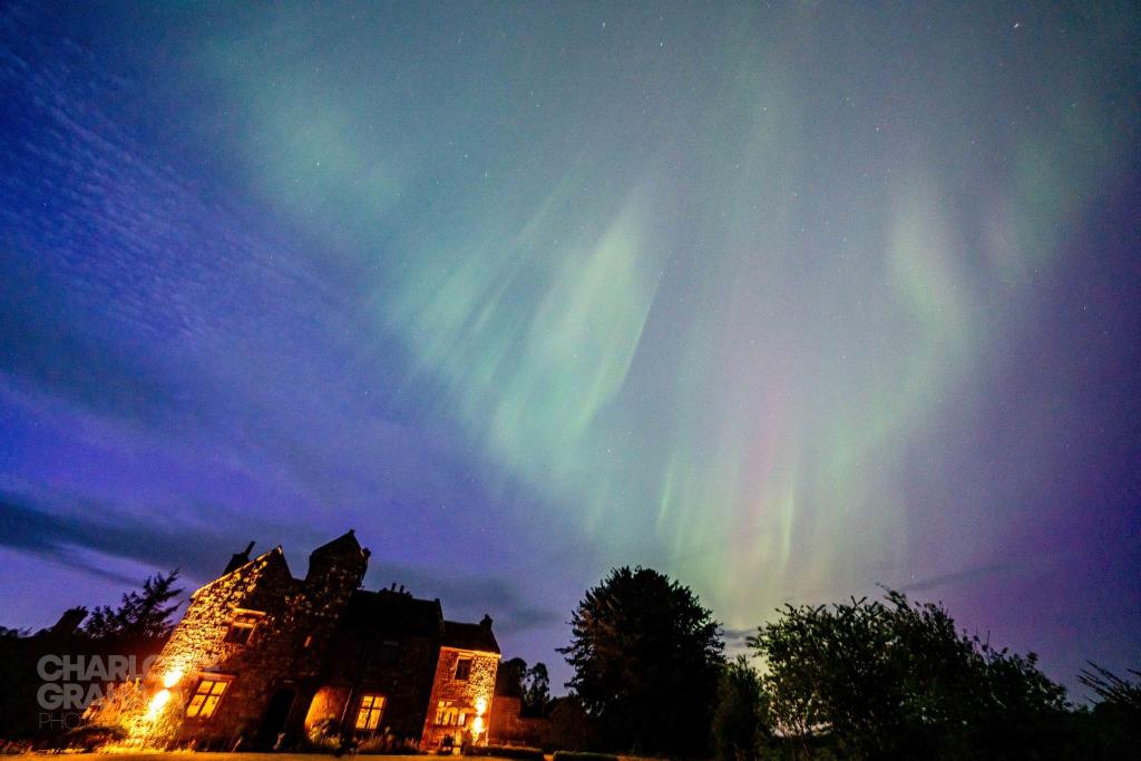 an image of the northern lights in the sky above a building at Abbey Farmhouse 