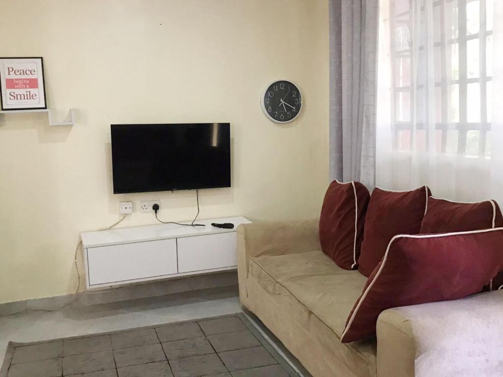 sala de estar con sofá y TV de pantalla plana en Summer Homes Bungoma, en Bungoma