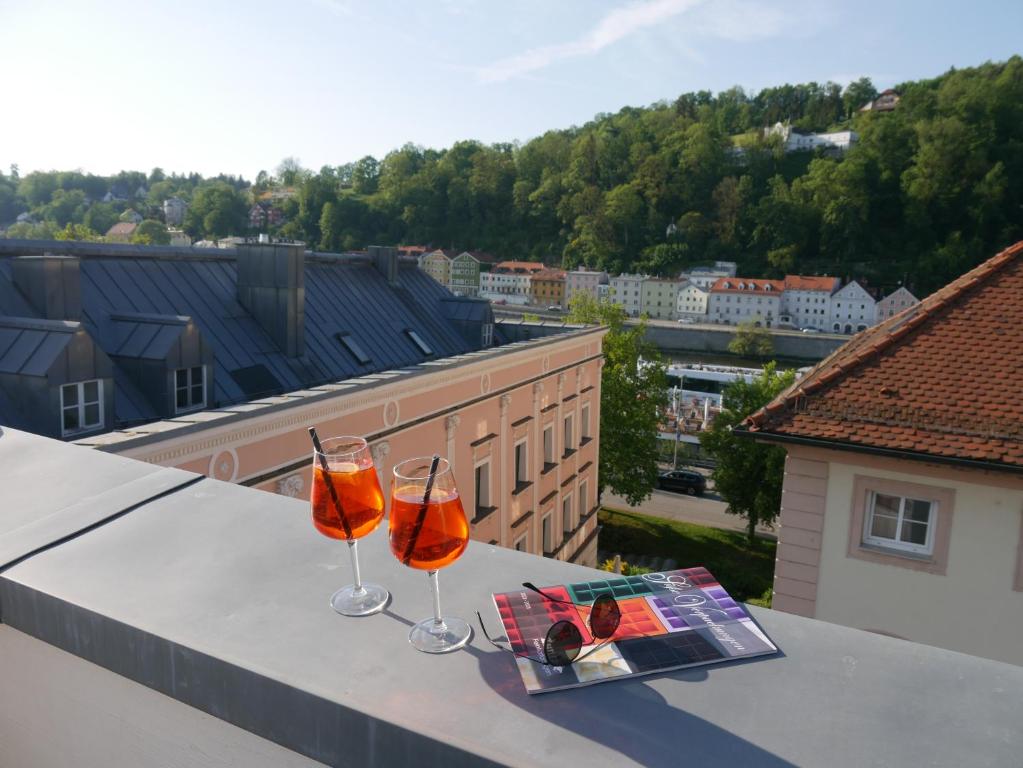 dois copos de vinho sentados numa mesa com uma revista em Penthouse - Zentral und Genial em Passau