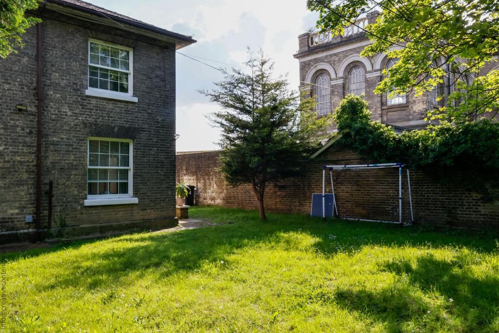 een lege tuin voor een bakstenen gebouw bij Hampton Court Cottage in Hampton