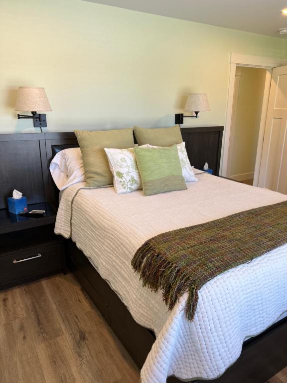een slaapkamer met een groot bed met kussens bij Wellington House in Nanaimo