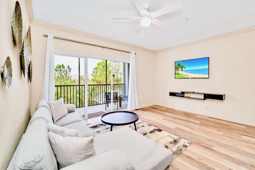 - un salon avec un canapé blanc et une fenêtre dans l'établissement 2BR Condo with shared Pool & Hot Tub, near Disney!, à Orlando