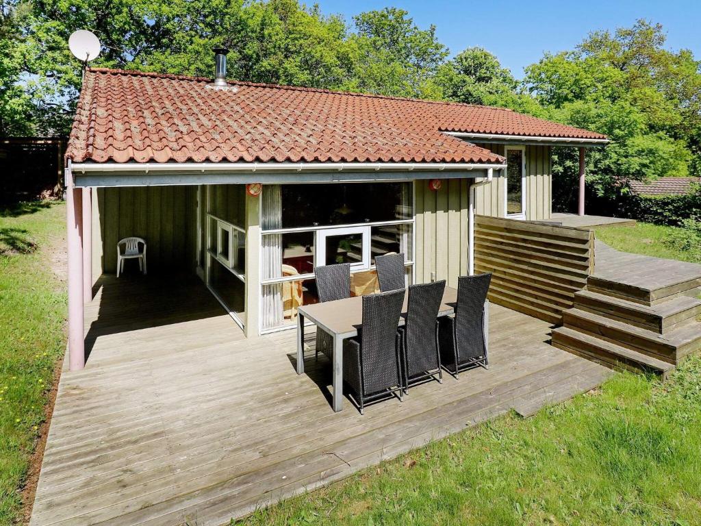 una gran terraza de madera con mesa y sillas en Splendid Holiday Home in Hadsund with Sauna, en Øster Hurup