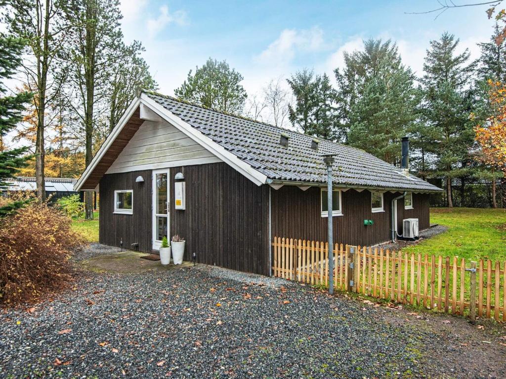 une petite maison avec une clôture devant elle dans l'établissement Holiday home Ansager XLI, à Ansager