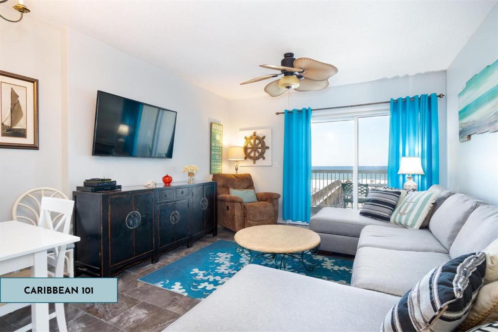 a living room with a couch and a tv at Caribbean By Liquid Life in Gulf Shores