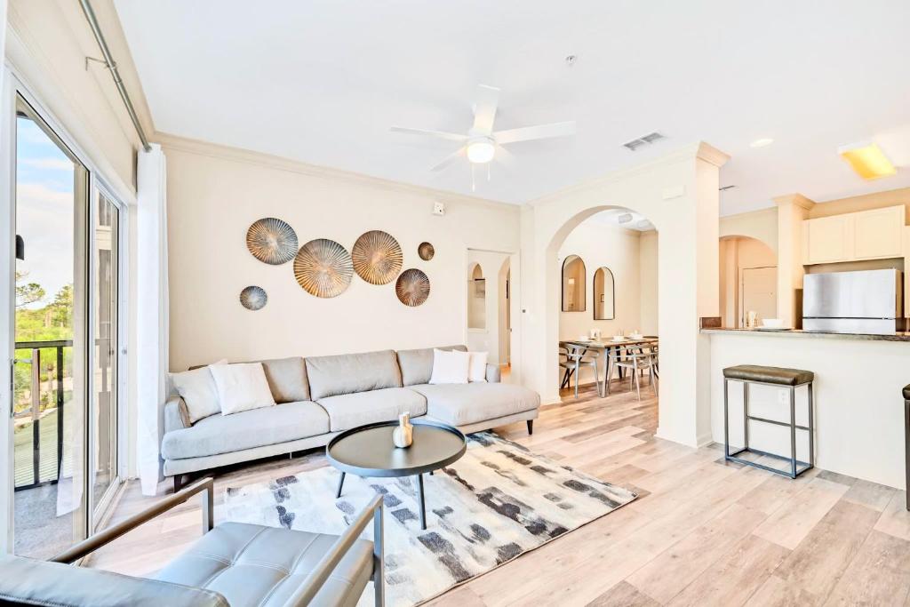 a living room with a couch and a table at Bright 2BR Condo with Pool and Hot tub - near Disney! in Orlando