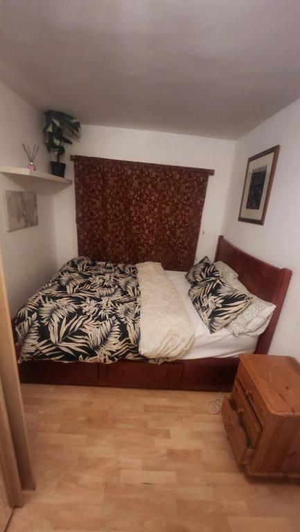 a bedroom with a bed with a wooden head board at Gold Lodge in London