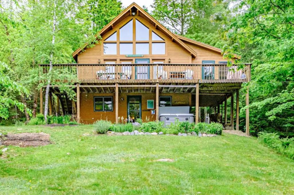 a large wooden house with a large deck at Gorgeous Chalet! VIEWS! Hot Tub! Sleeps 12! Games in Bethel