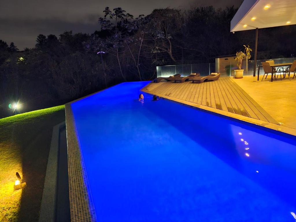 una piscina azul por la noche con patio en CASA SAN JOSE en San José