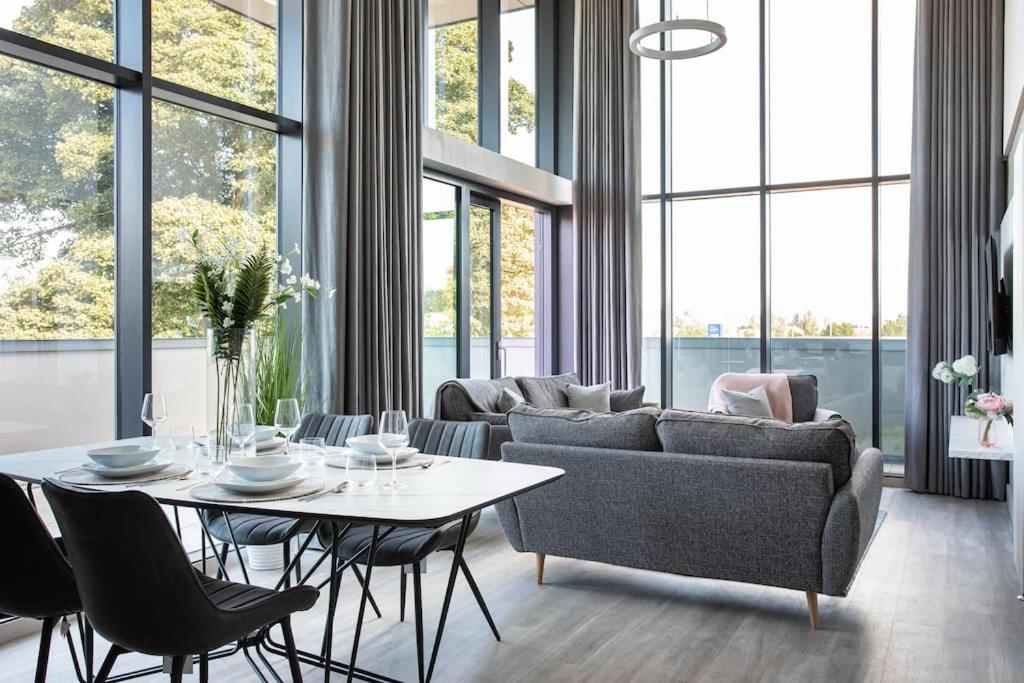 a living room with a table and chairs at Skyline Serenity: Exquisite 3-Bedroom Ultra-Luxury Penthouse in Belfast
