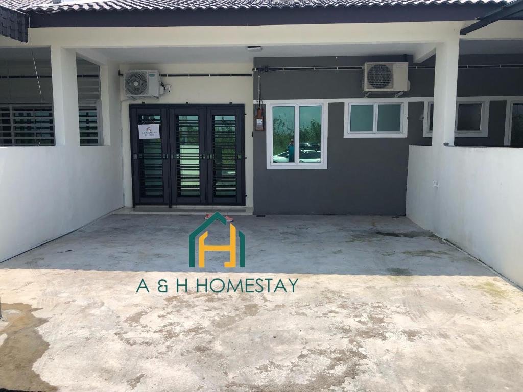 un cartel de "Homesay" delante de una casa en A&H Homestay Teluk Intan en Teluk Intan
