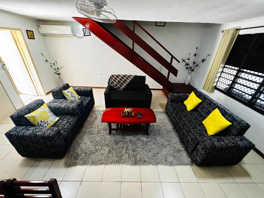 ein Wohnzimmer mit 2 Sofas und einem roten Tisch in der Unterkunft Cozy, Comfortable, Family Home. in Nadi