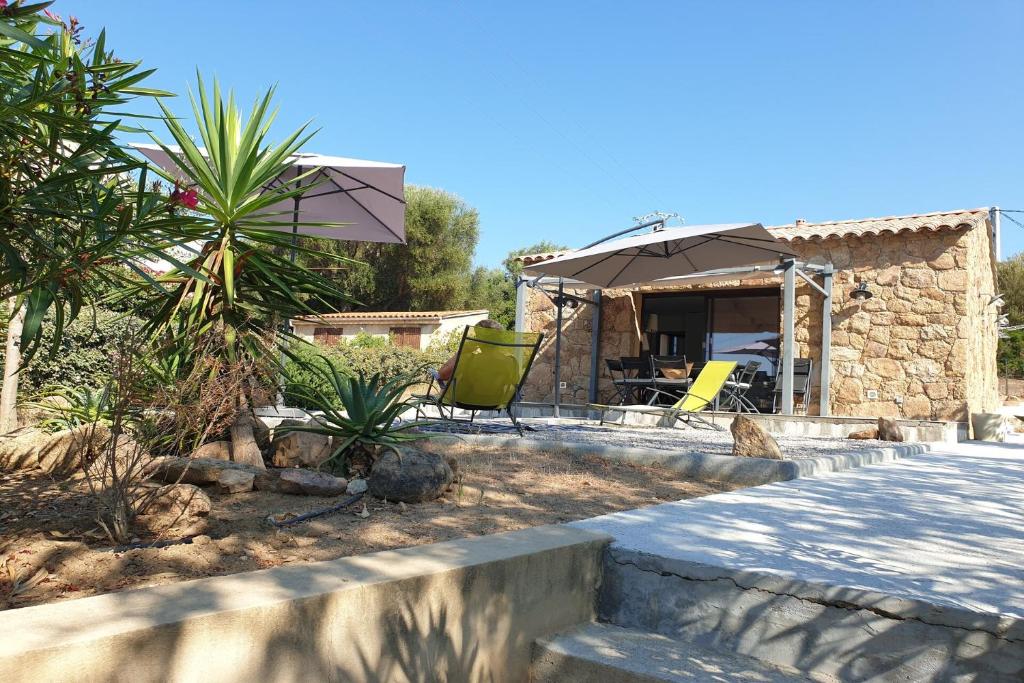 un patio con due sedie da giardino e un ombrellone di U caseddu di a Castagna a Coti-Chiavari