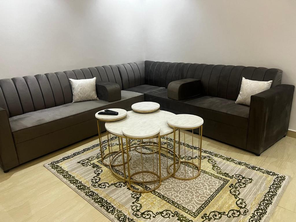uma sala de estar com um sofá e uma mesa em شقة بدخول ذاتي غرفتين نوم وصالة em Al-Kharj
