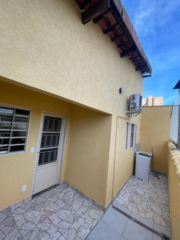 a yellow building with a door and a trash can at Apto 3 otimo Local próximo Shopping in Campo Grande