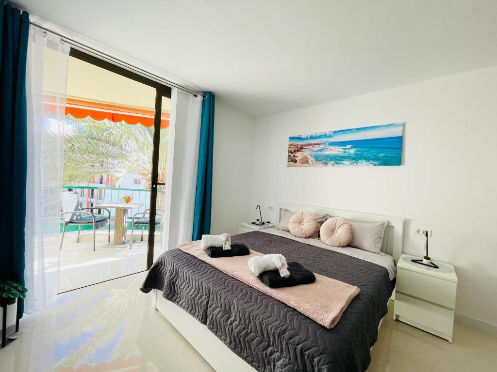 una camera con un letto e una grande finestra di Royal View Apartment - Los Cristianos a Los Cristianos