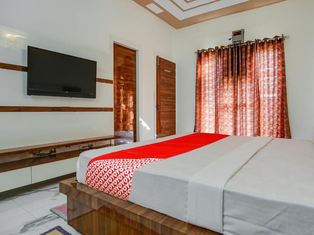 a bedroom with a bed and a flat screen tv at OYO Hotel Yellow Stone in Patiāla