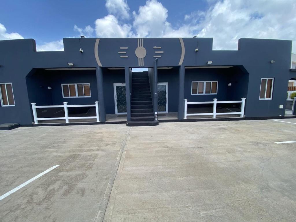 a large blue building with a door in a parking lot at Delta Alpha Apartments in Calliste Land Settlement