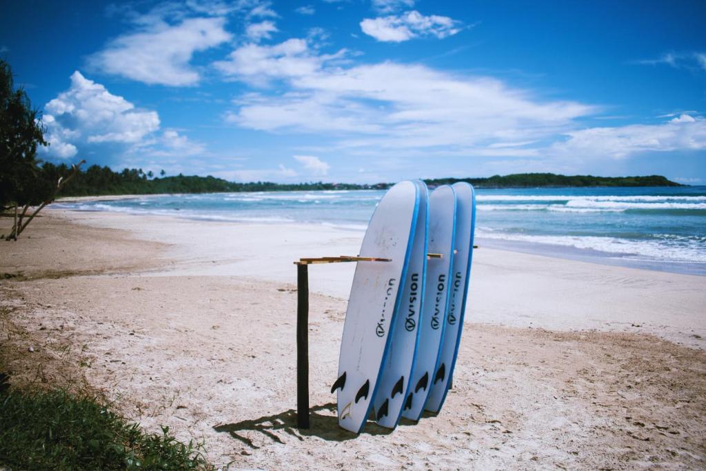 a couple of surfboards sitting on a beach at Calma - Surf, Yoga & Coffee on a Private Beach in Dickwella