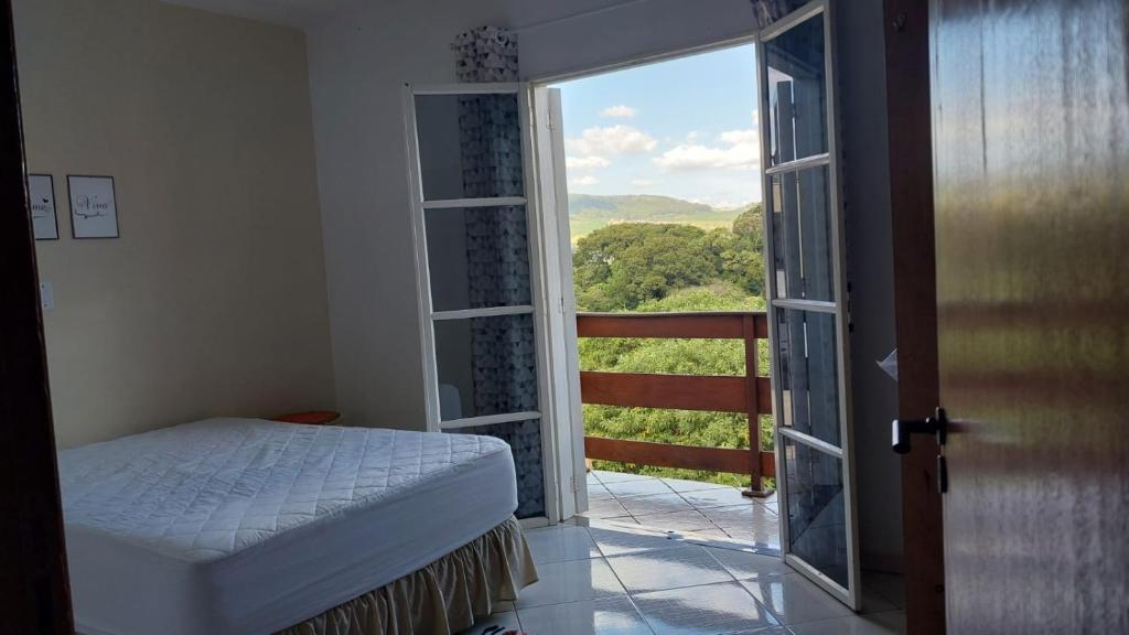 una camera con un letto e una grande finestra di Casa com linda Vista no Centro a Serra Negra
