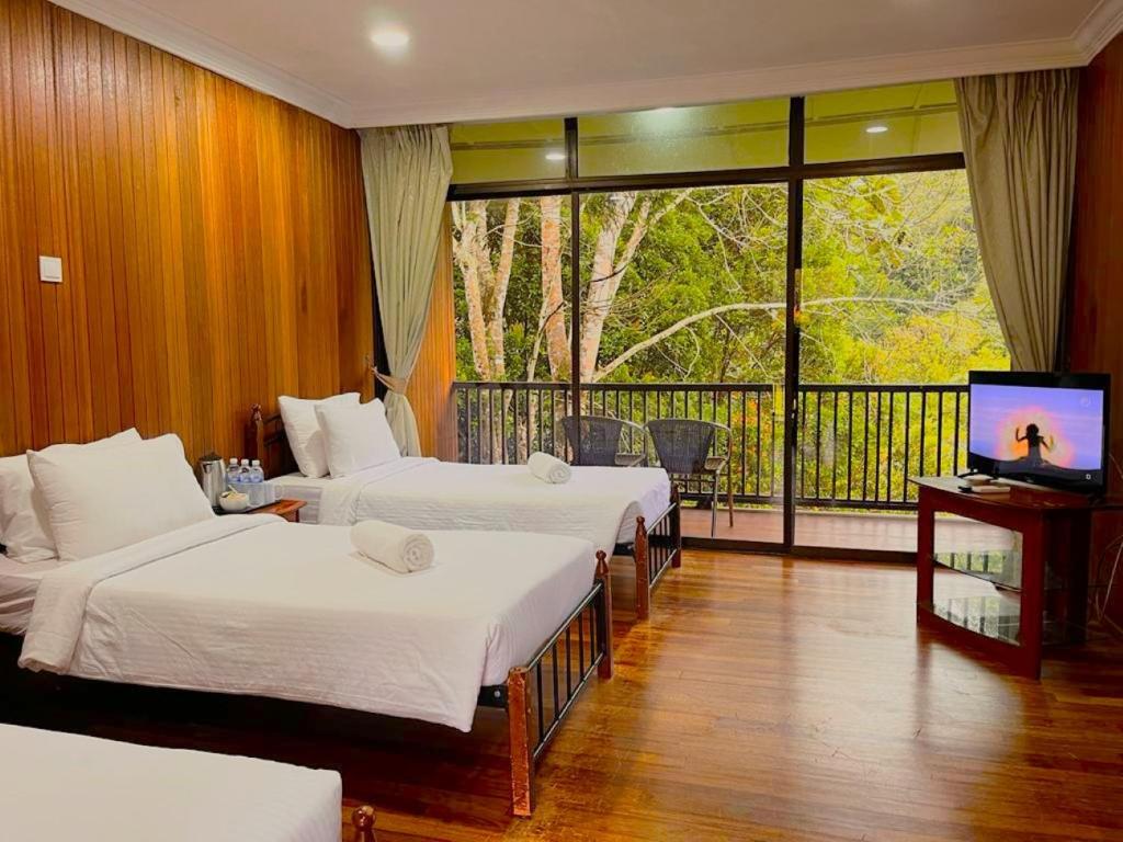 een hotelkamer met 3 bedden en een balkon bij LiLLA Hilltop Retreats Janda Baik formerly known as Serene Resort in Bentong